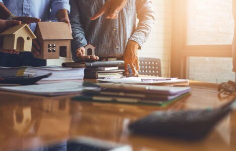People gather around a table and discuss about properties