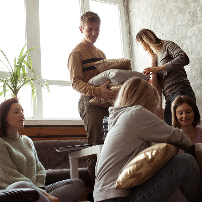 Active, fast, playful students sit on the floor, packing baggage for traveling and relocation, moving out to new place. Education start for first year students. Unpacking bags, showing out room