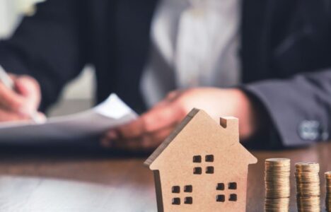 Modeling wooden houses and coins and dollars placed on wooden tables,preparation concept for house model purchase and the fastest growing real estate economy,moving home or renting property via agent