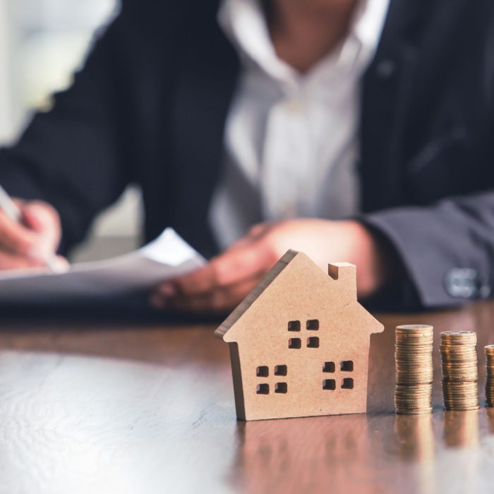 Modeling wooden houses and coins and dollars placed on wooden tables,preparation concept for house model purchase and the fastest growing real estate economy,moving home or renting property via agent