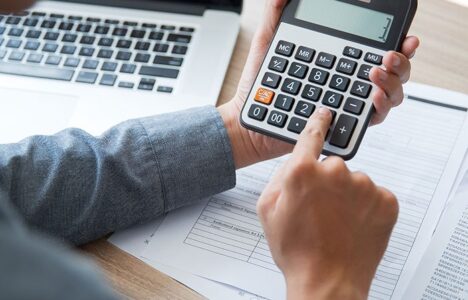 A person is using calculator to fill in the document