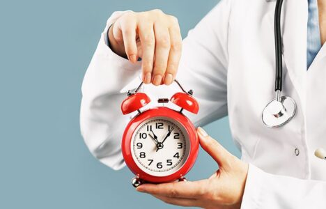 A doctor holds a clock