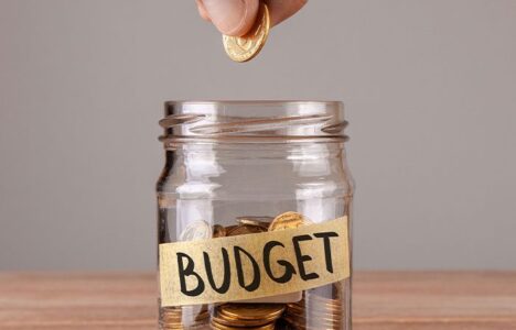Hand putting a coin into a jar