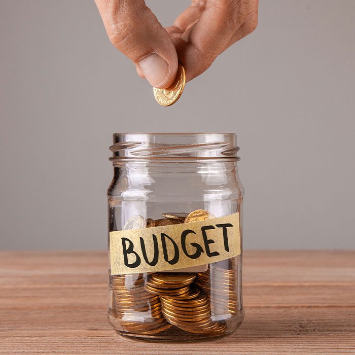 Hand putting a coin into a jar
