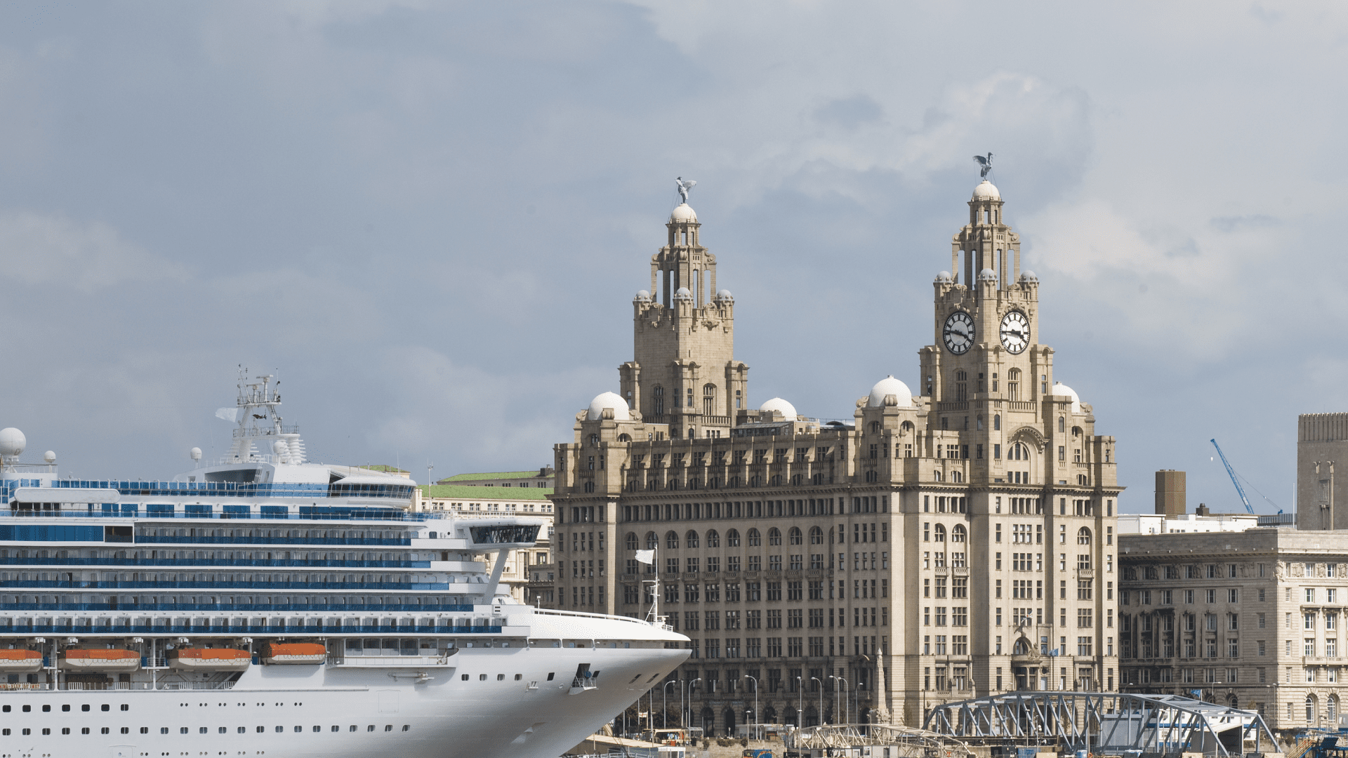 Liverpool waterfront view of Liver Building and cruise ship during the daytime showing city attractions