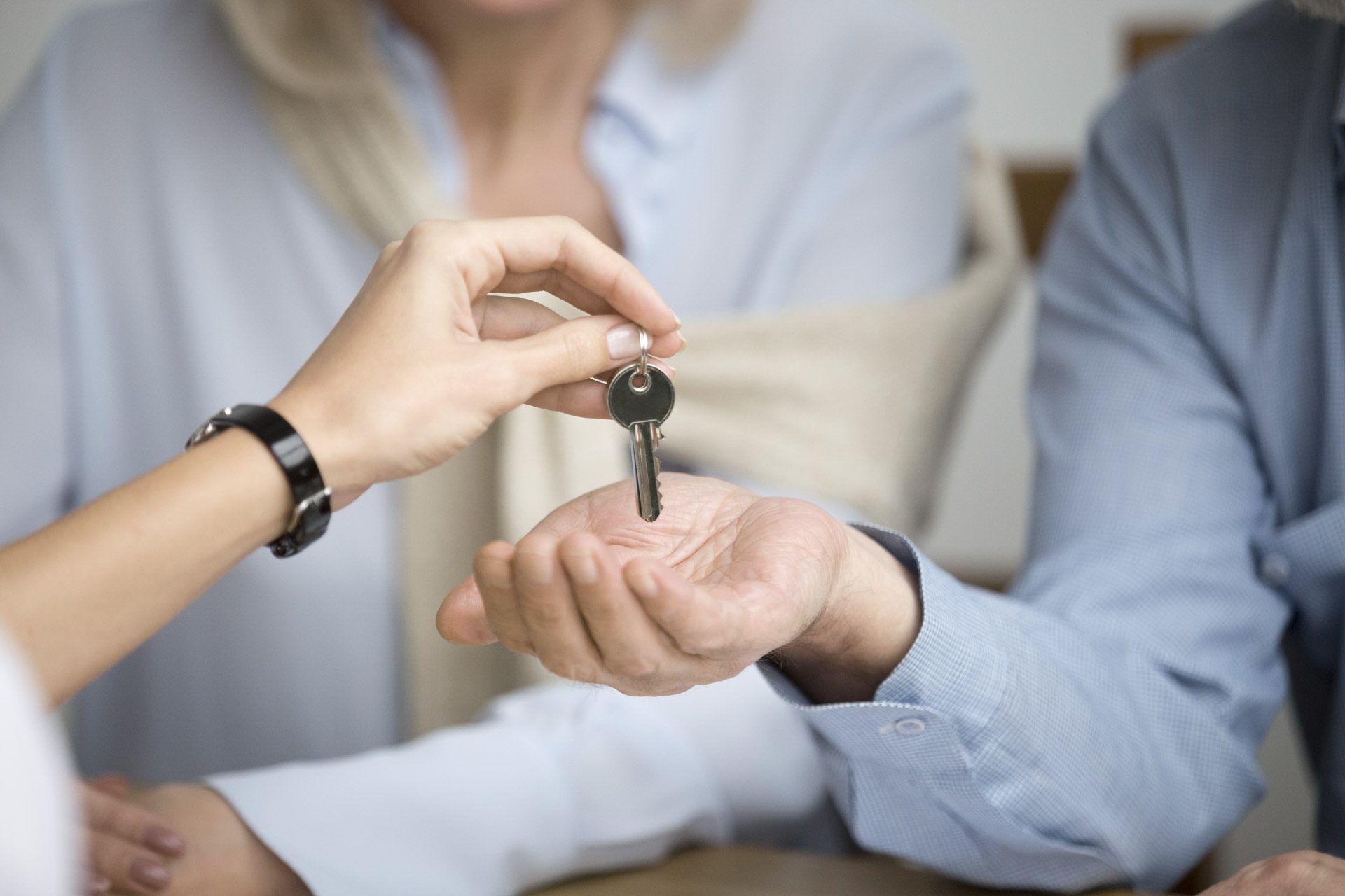 Couple of homeowners getting key to new house apartment from realtor, happy real estate owners make purchase deal, family mortgage investment and buying property concept, close up view of hands