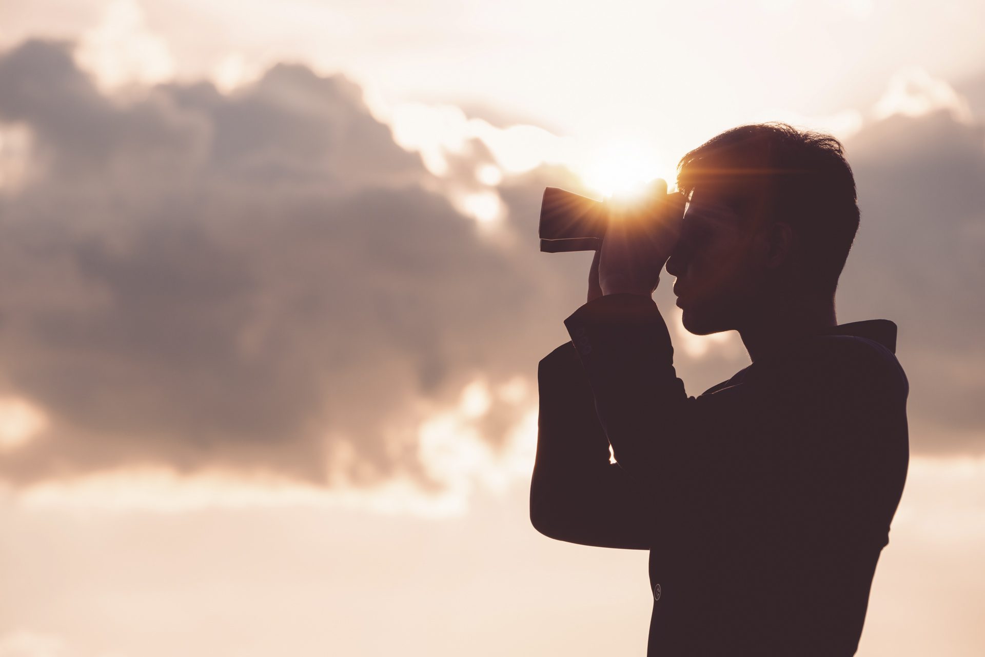 Asian man Hand Holding Binoculars / looking / watching using Binoculars with copyspace,Concept of The pursuit of profitable business in the future.