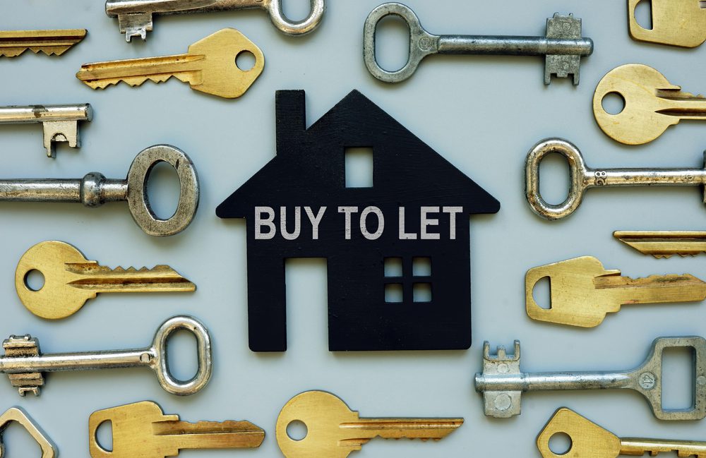 House shape in black with 'buy to let' text surrounded by keys on blue background
