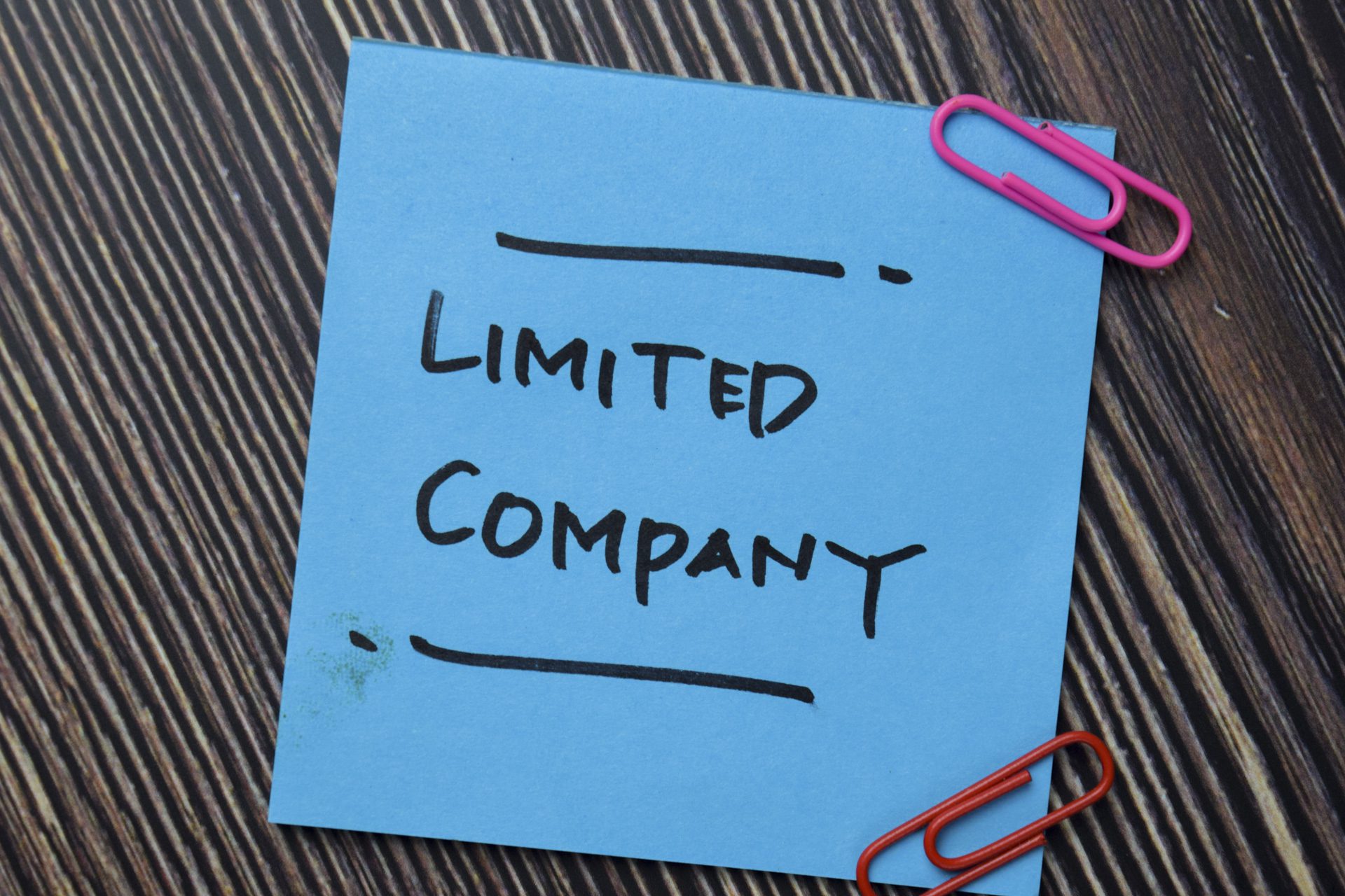 Blue sticky note on desk reading 'limited company' to represent incorporation in property investment