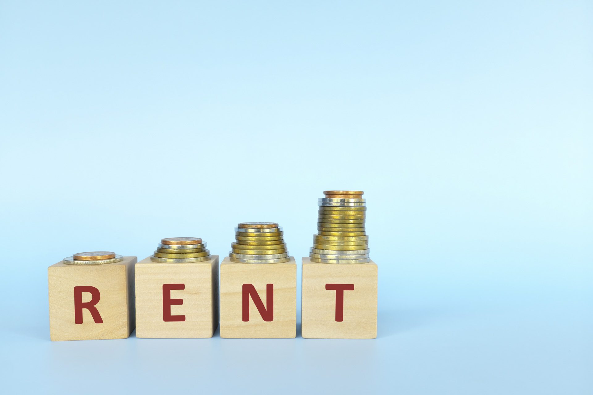 Increasing coins on wooden blocks reading 'rent' to represent UK rental inflation