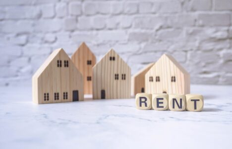 House and wooden blocks with the word rent on marble table representing rental inflation and rental demand in UK market