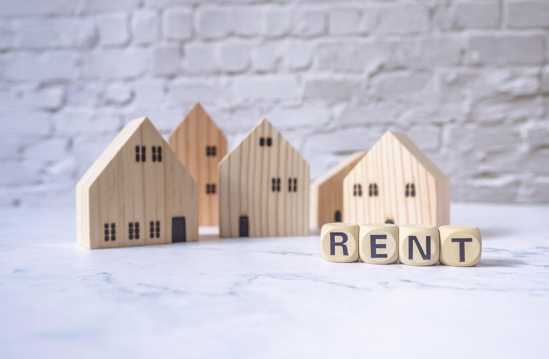 House and wooden blocks with the word rent on marble table representing rental inflation and rental demand in UK market