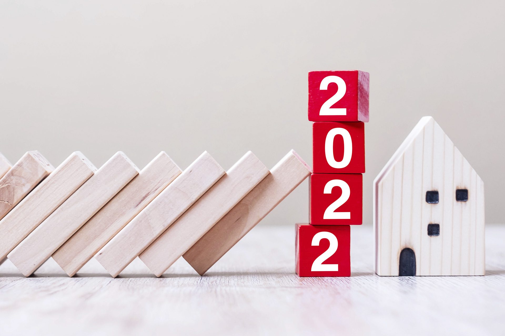 Red 2022 cube blocks stop falling blocks protect house miniature. fall Business, Home Insurance, investment, Crisis, Economic recession, New Year, Real Estate and Property concept