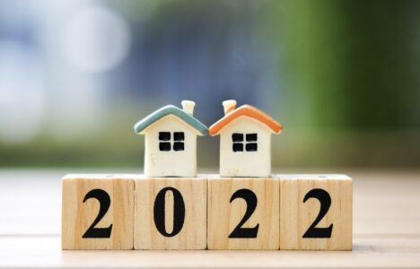 Two house model on 2022 wooden blocks number. New year property investment concept.