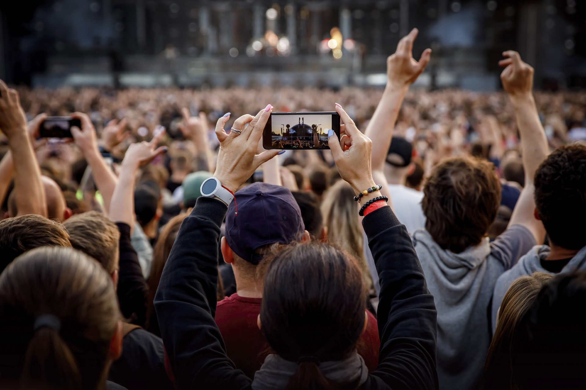 Smartphone in the hand of a music fan at the summer concert