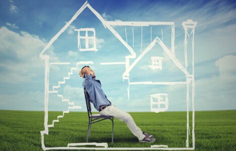 A safe house. Happy man enjoying his day in a new home surrounded by green summer meadow