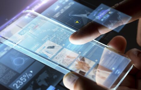 business, people, mass media and technology concept - hands with business web page on smartphone screen over black background