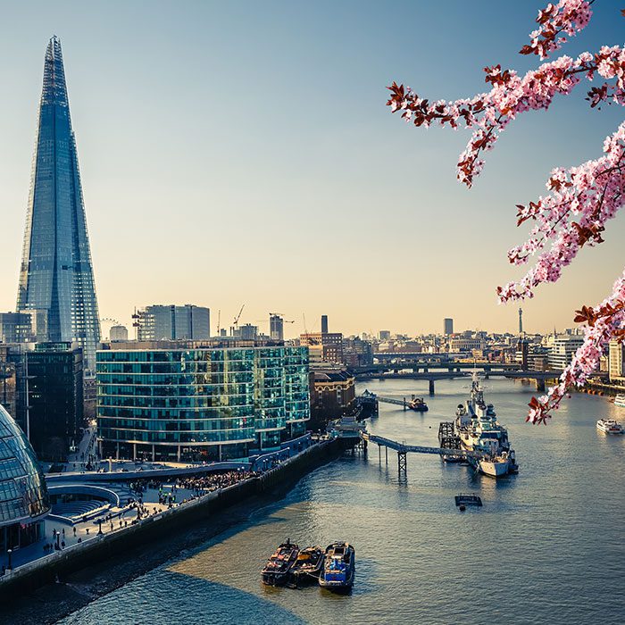 A photo of a London by the Thames, with boats and bridges all around.