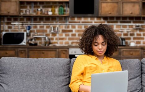 Lady sitting on a sofa with her laptop