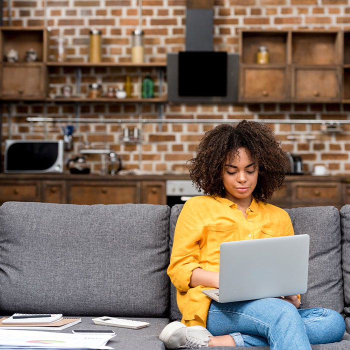Lady sitting on a sofa with her laptop