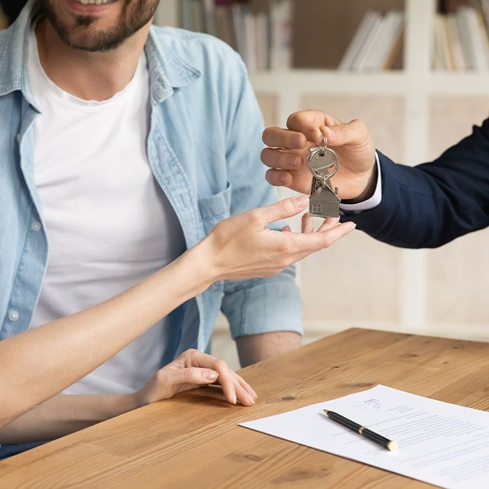 Landlord handing keys to the tenant after signing contract for a short term let