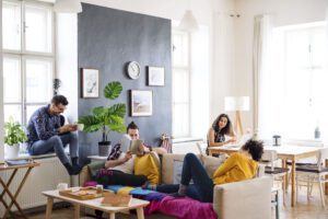 Four students comfortable in living room of student accommodation rental property