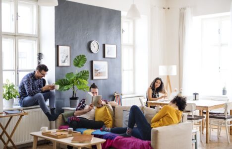 Four students comfortable in living room of student accommodation rental property