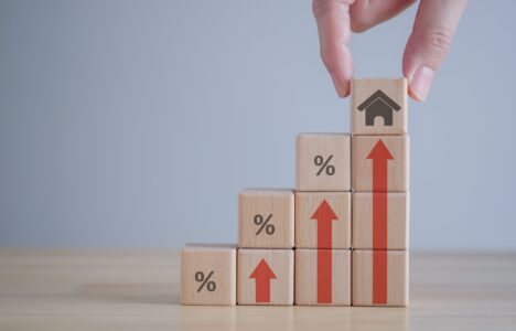 Wooden blocks with percentage signs and house symbol representing interest rates in UK property market