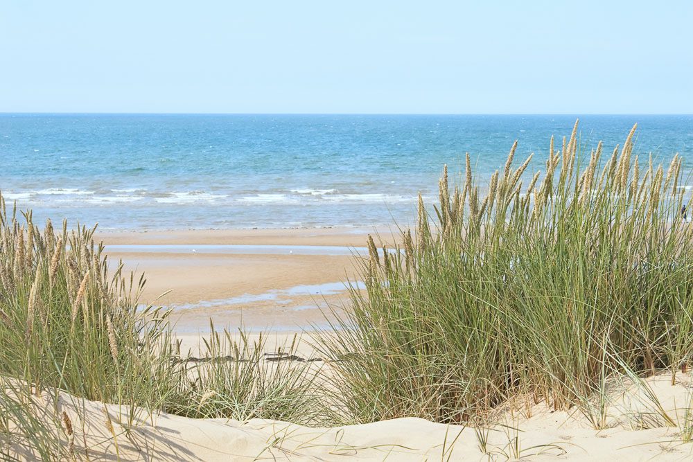 North West popular buy-to-let coastal area Formby Beach showing dunes, sand and sea under a blue sky