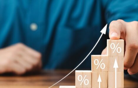 Person pointing at stacks of blocks representing a rise in statistics