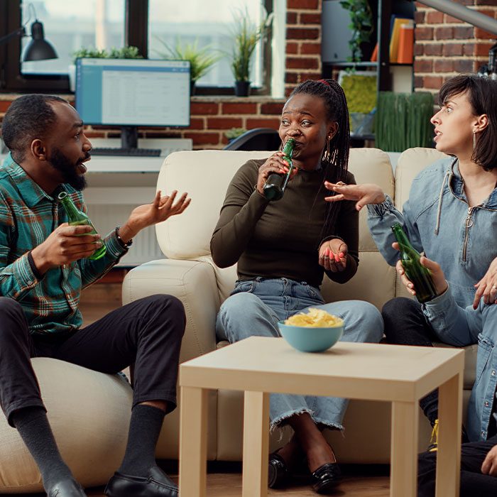 People sit on the sofa, chatting and drinking