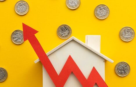 Arrow increase in front of a house model with coins in the background