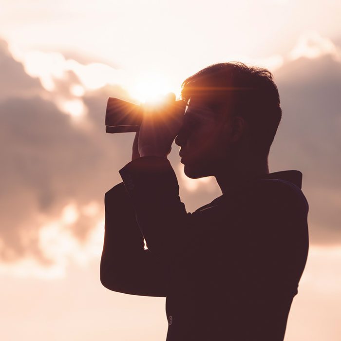 Asian man Hand Holding Binoculars / looking / watching using Binoculars with copyspace,Concept of The pursuit of profitable business in the future.