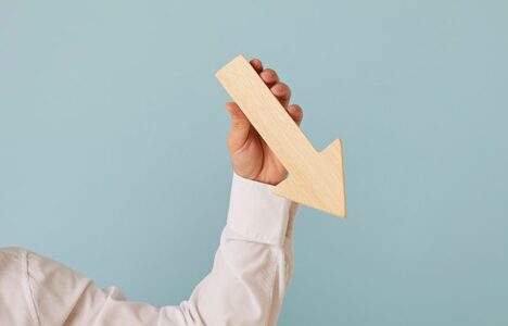 A person holds an arrow pointing down