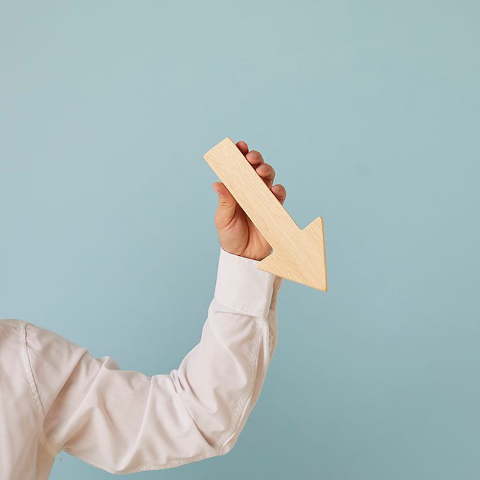 A person holds an arrow pointing down