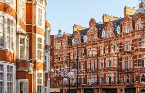 A row of terraced houses in Greenwich Bexley, that can see skyscrapers in the background.