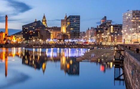 Liverpool waterfront at dusk, with the Three Graces illuminated.