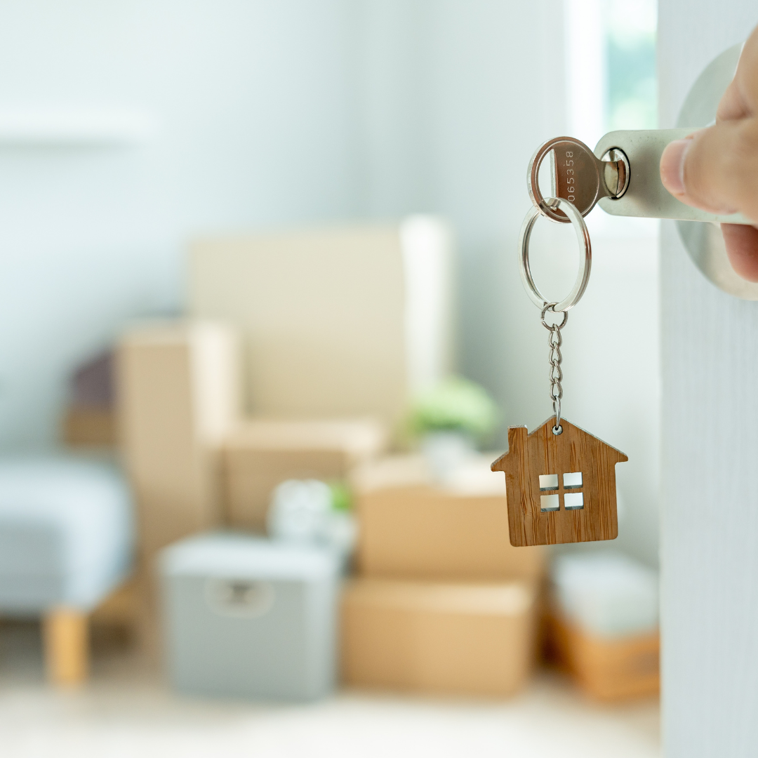 Person moving into new property with boxes and set of keys