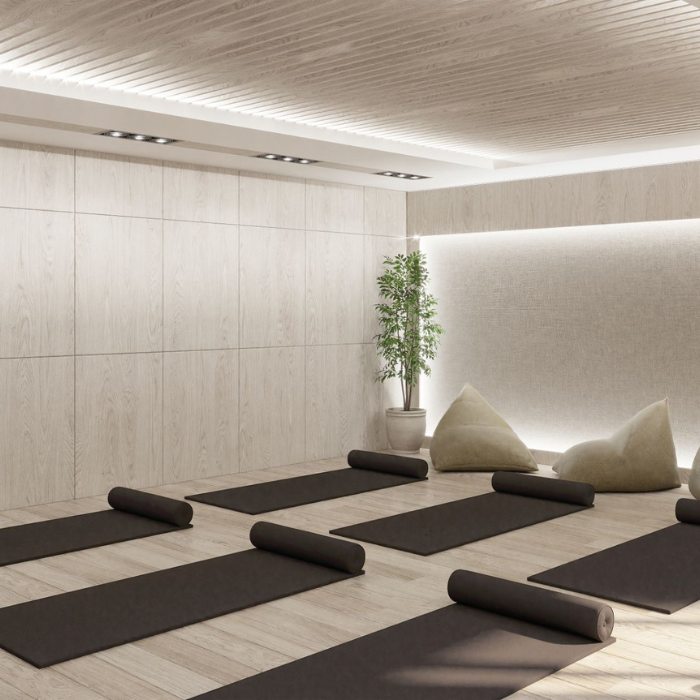 A modern yoga and pilates studio at Parliament Square with wooden walls, a wood-paneled ceiling, and several yoga mats lined up on the floor.