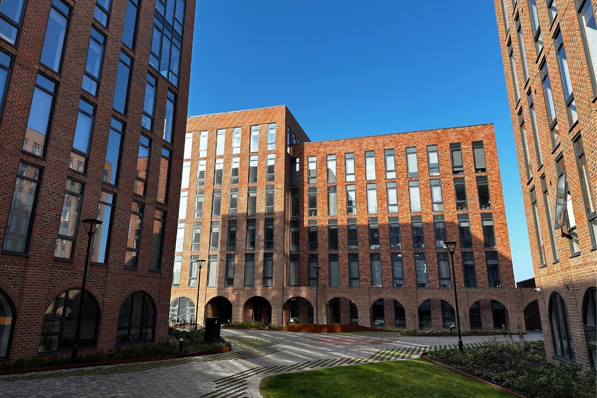 Image of the exterior of One Baltic Square development, with blue sky and shadow on the building