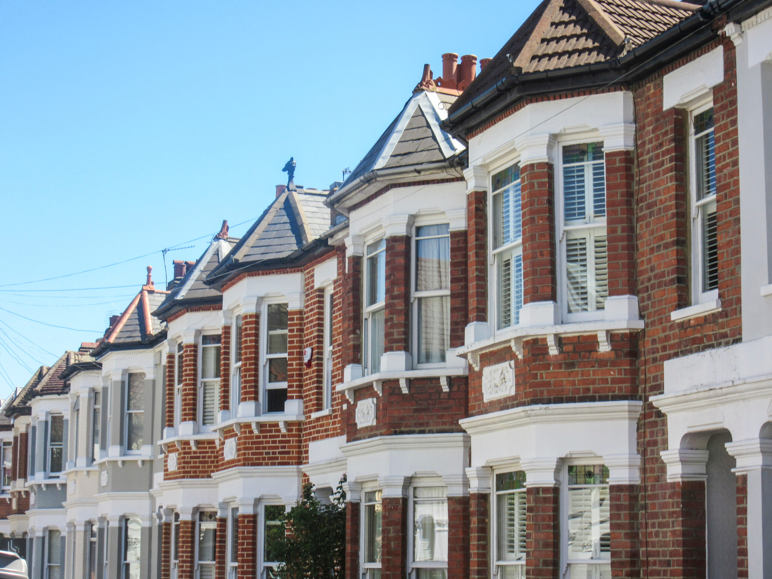 Row of terraced houses in the UK, with blue sky