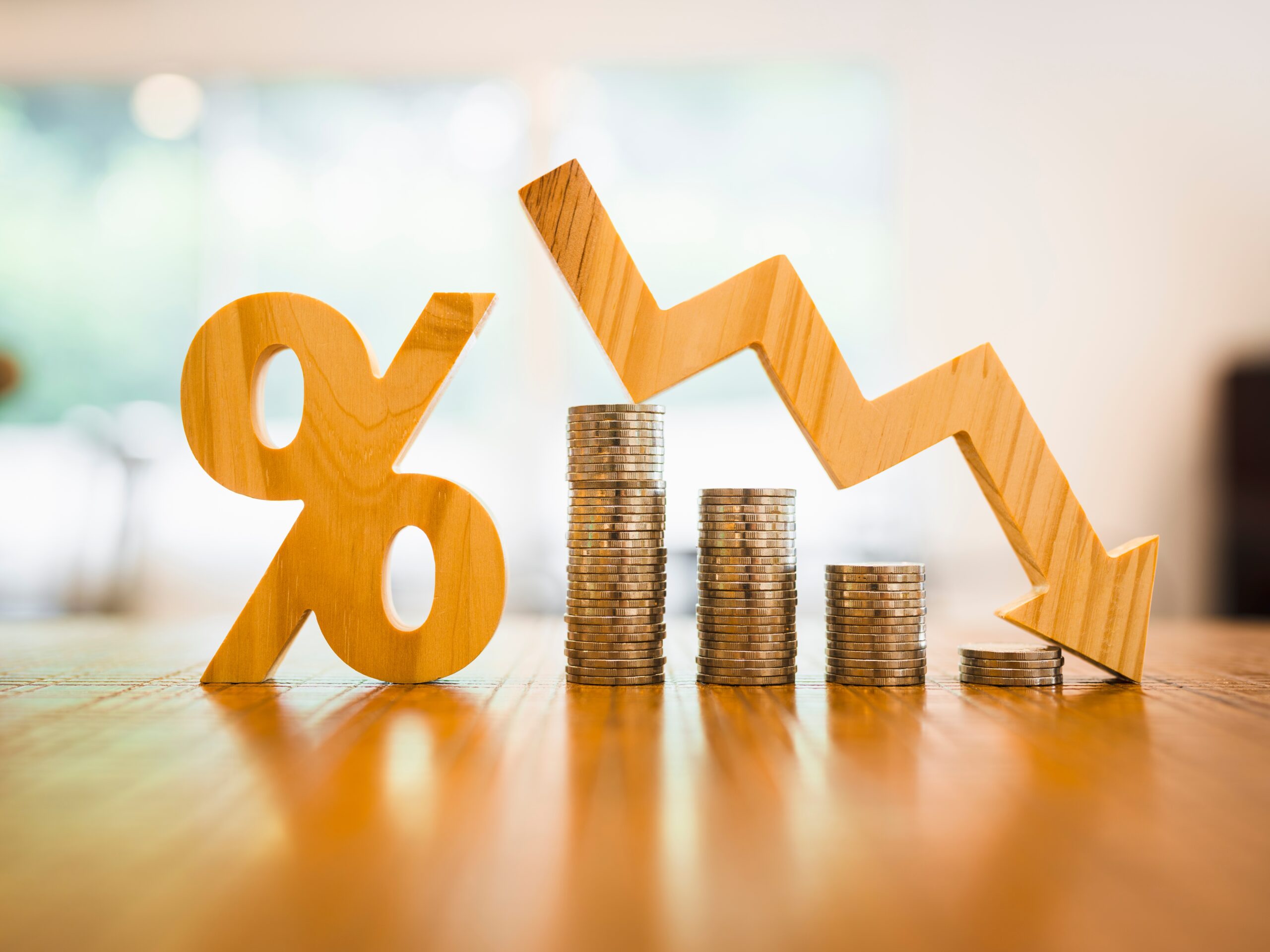 Image depicting lowering interest rates, with coins, a percentage figure and a downward figure