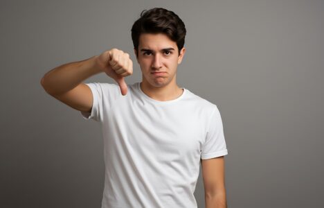 man wearing white shirt doing a thumb down gesture