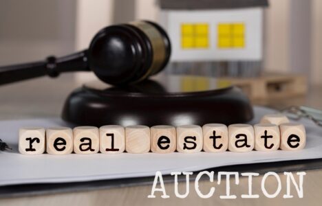 real estate spelled on wooden cubes with a gavel as background