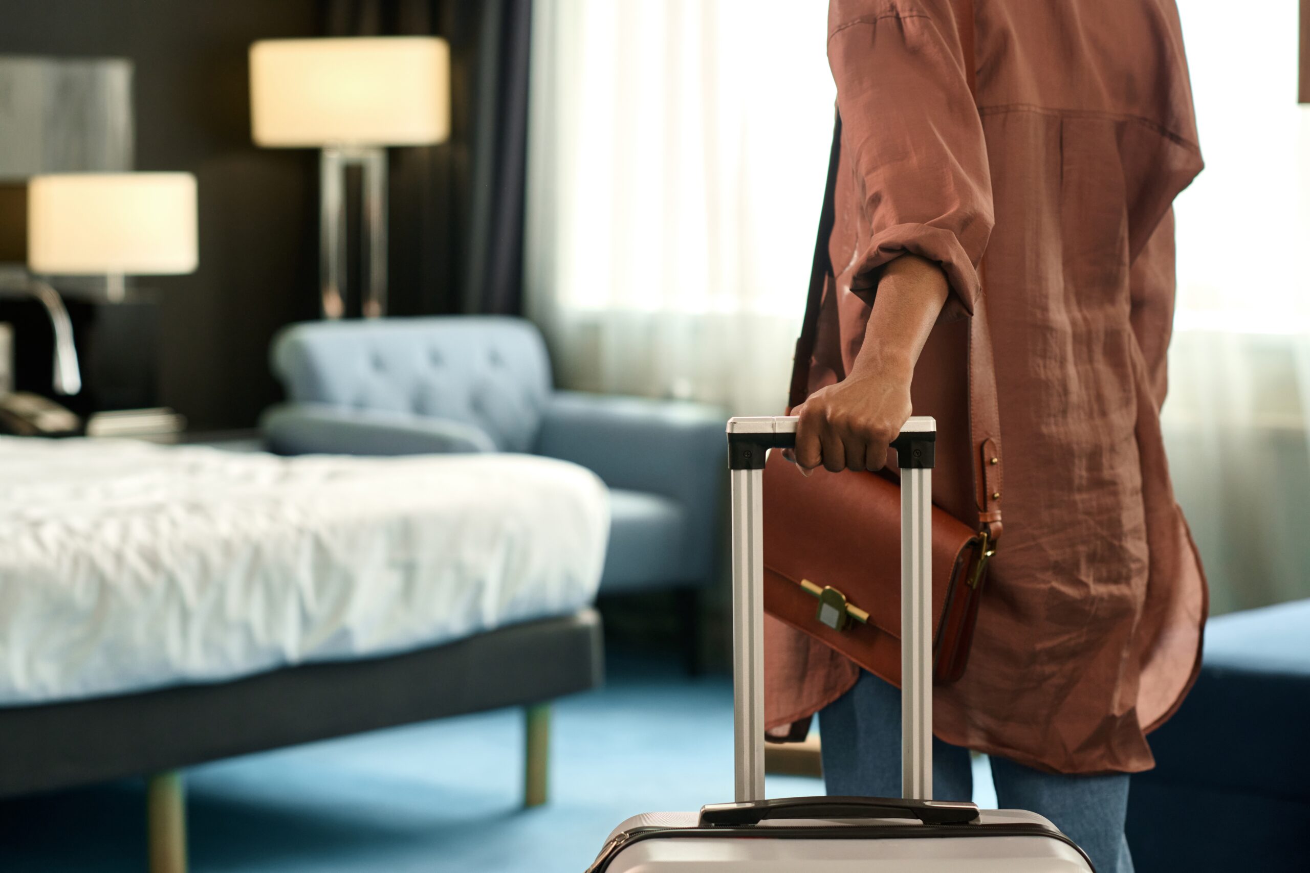 Woman walking into serviced accommodation with suitcase