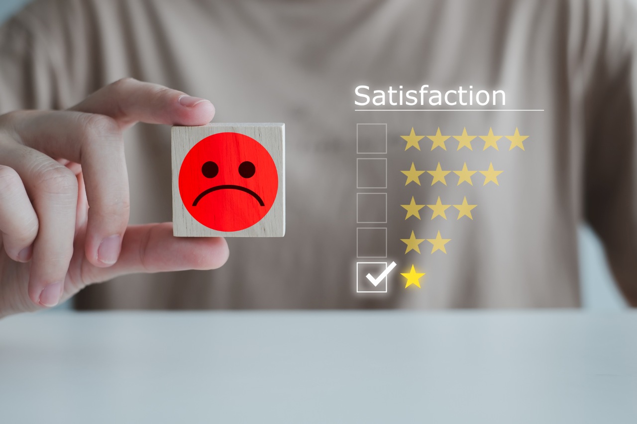 hand showing sad face icon on wood cube with 1 star depicting negative feedback