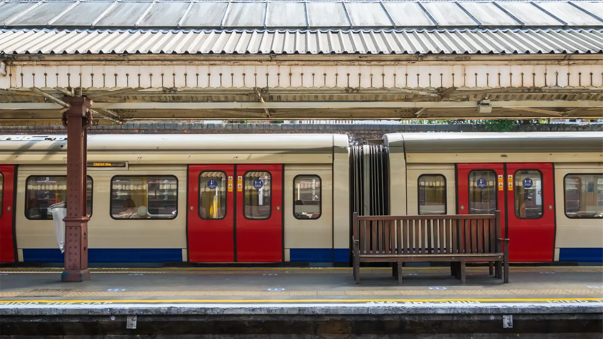 Train at station with red doors and railway visible